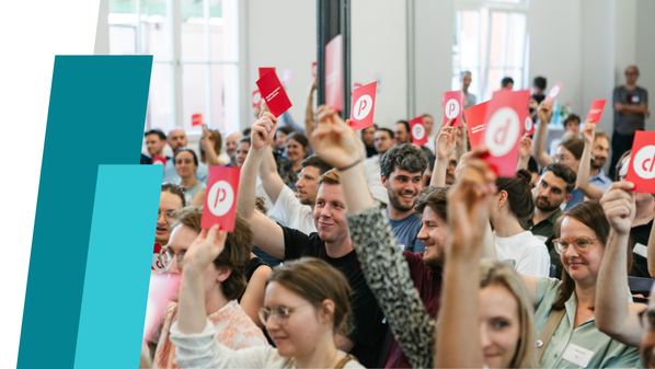 Viele Menschen halten Postkarten mit Prognos-Logo hoch