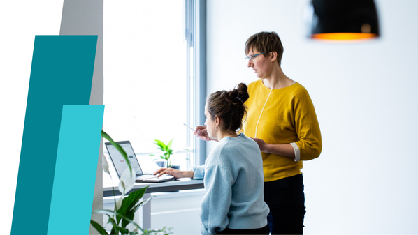 Zwei Personen sprechen an einem Computer