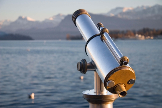 Fernrohr mit Blick über einen See in der Schweiz.