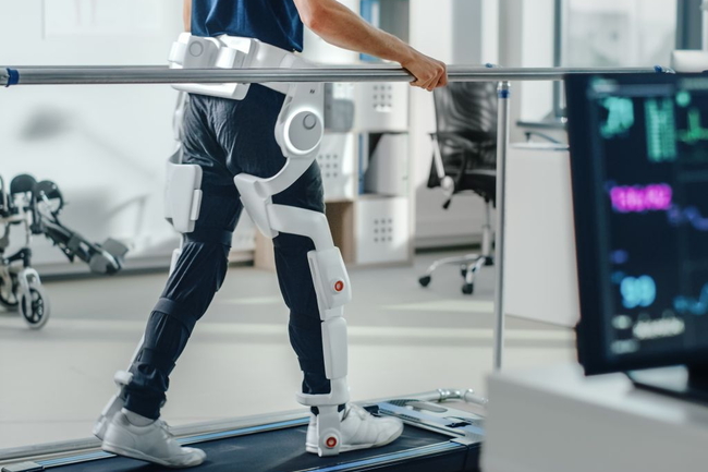 Patient mit Verletzungen geht auf dem Laufband mit fortschrittlichen Roboter-Exoskelett-Beinen