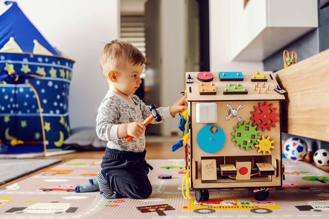 Junge im Kindergartenalter spielt mit Holzspielzeug