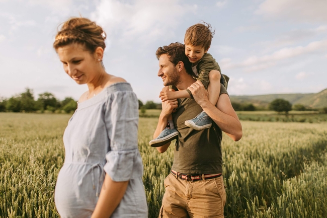 Eine junge Familie läuft durch ein Feld