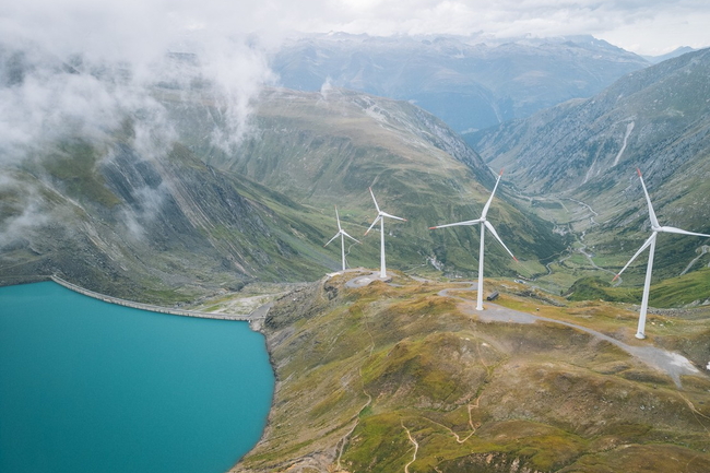 Schweizer Alpensee mit Windrädern