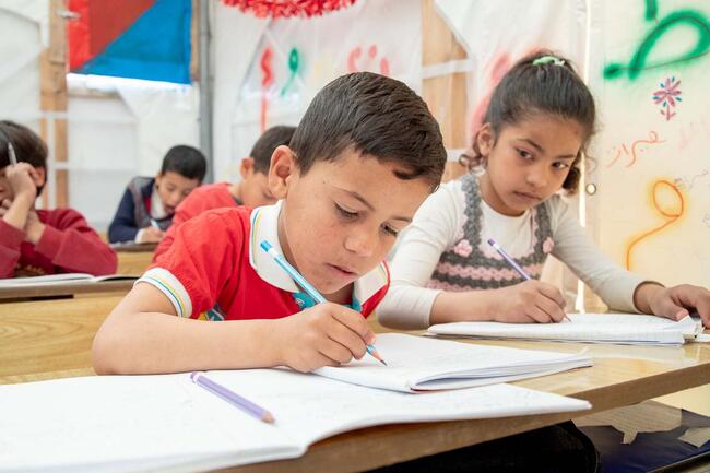 Kinder beim Unterricht in einer Zeltschule 