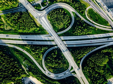 Luftaufnahme von Autobahn und Überführung mit grünen Wäldern