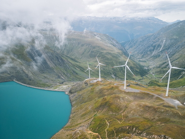 Schweizer Alpensee mit Windrädern