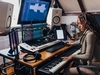 Coole und kreative Künstlerin, die an der Audioproduktion arbeitet, von zu Hause aus, in ihrem modernen Musikstudio.